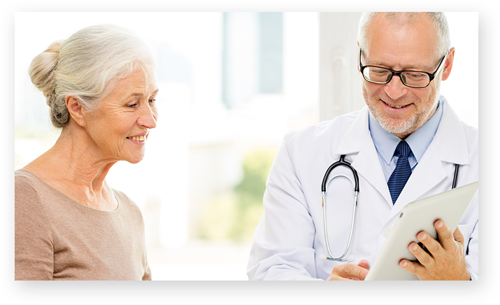 Doente e médico, lado a lado, a olhar para um tablet.